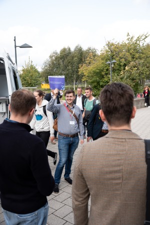 Mann hält Workshop Schild bei den Treffpunkten vor dem Audimax hoch