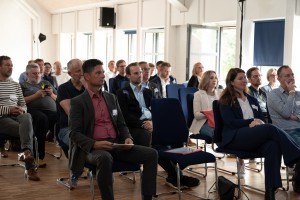Oberbürgermeister Fabian Geyer und weitere Menschen beim Hören eines Vortrages
