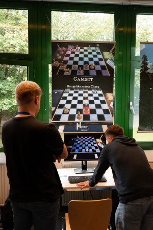 Zwei Männer schauen sich das an der Hochschule Flensburg programmierte Spiel "Gambit" an